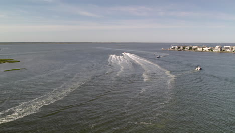 Barco-Que-Se-Aleja-A-Toda-Velocidad-Del-Dron-Con-Dos-Motos-Acuáticas-Siguiéndolo-De-Cerca-En-Long-Beach-Island