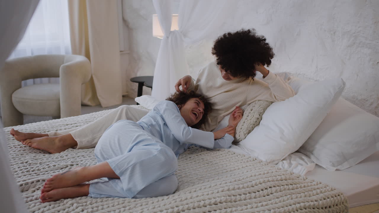 una pareja feliz hablando en la cama.