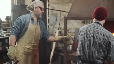 two blacksmiths working together in forge