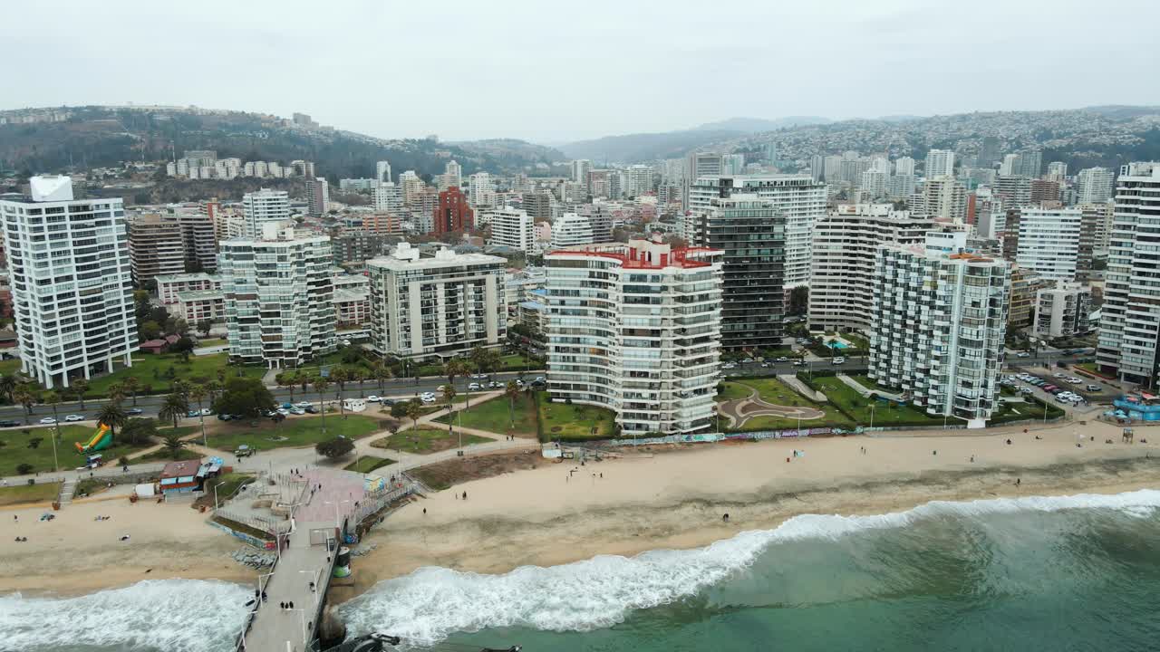 toma aérea de establecimiento de la ciudad de viña del mar con montañas y cielo nublado detrás