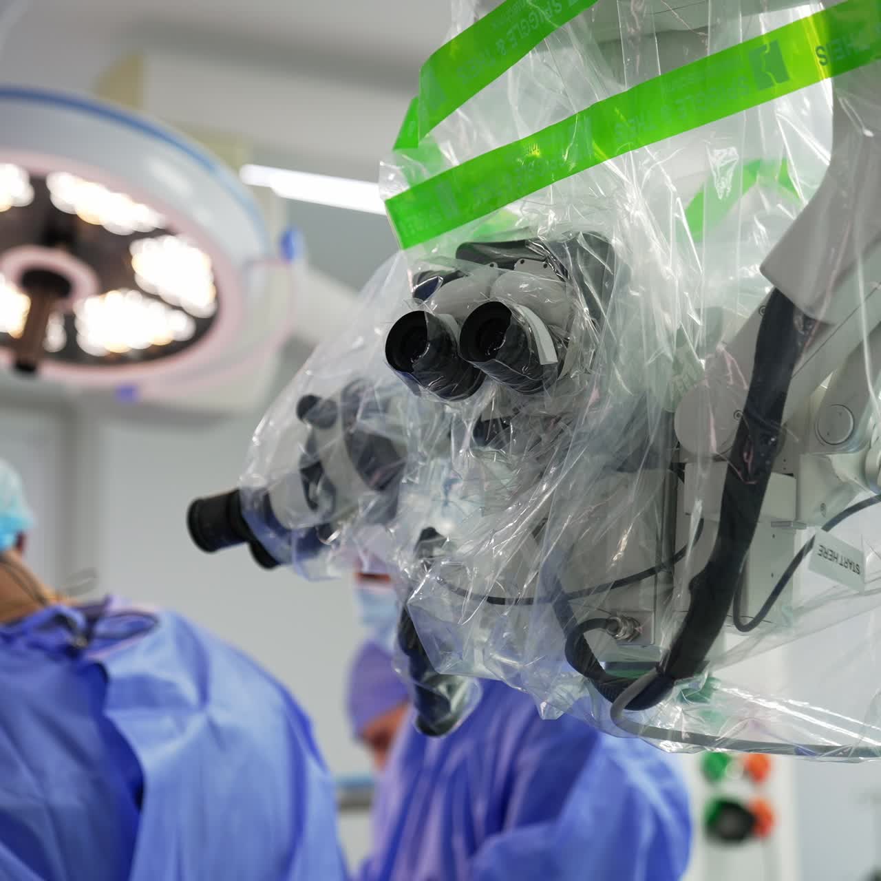 Advanced technological equipment coated with plastic. Surgeons working at surgery room at backdrop in blur