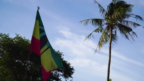 rasta flag and palm tree on a sunny day