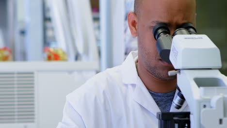 científico mirando a través del microscopio 4k