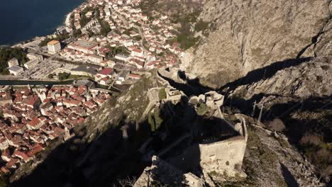 aerial - city walls and bay of kotor, montenegro, world heritage site, top down tilt up