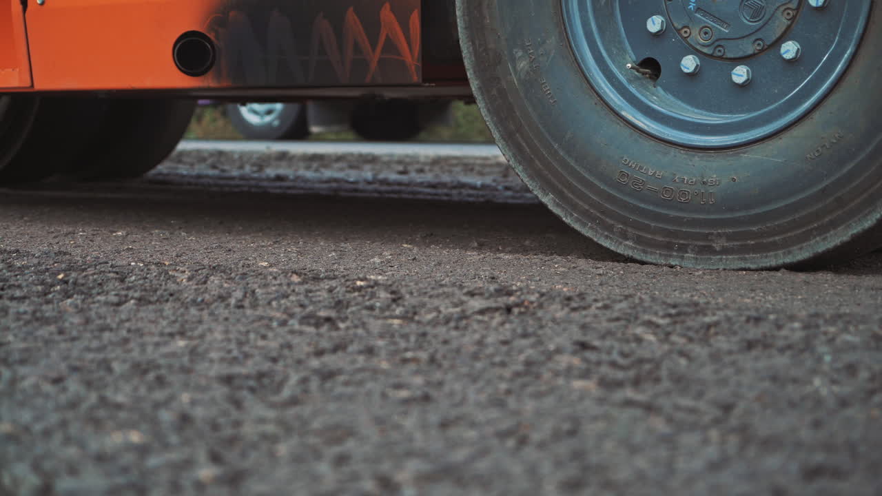 Laying a new asphalt on the road. Road repair machine with heavy vibration roller compactor