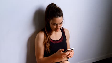 mujer hablando por teléfono móvil en el estudio de fitness 4k