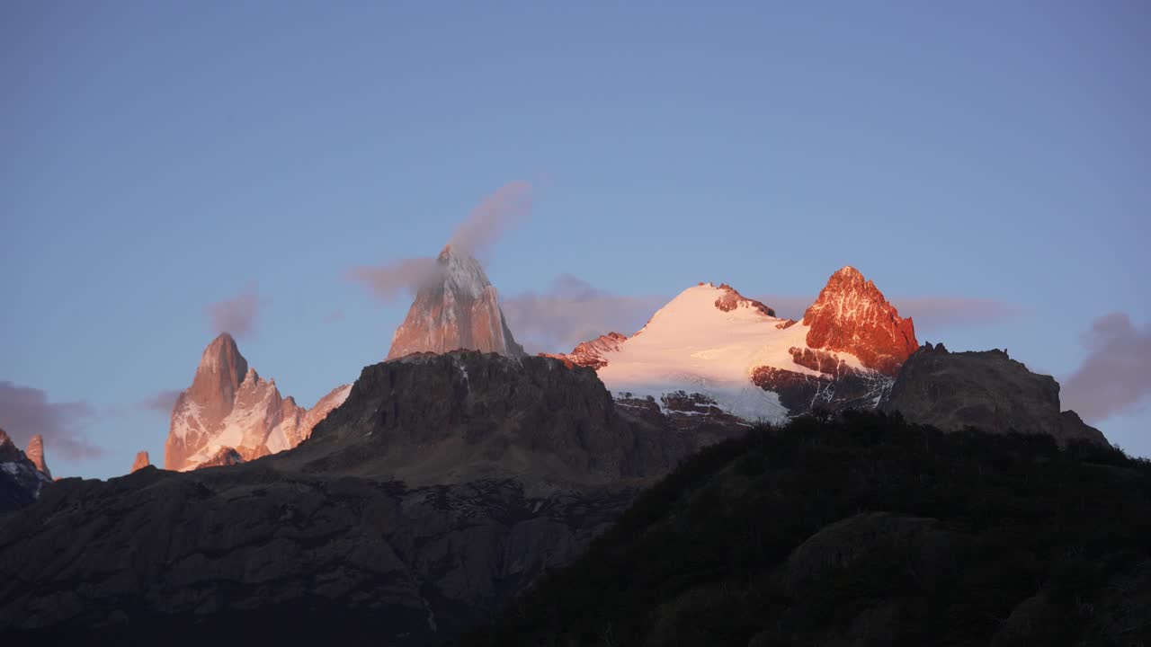 Cerro Electrico and Mount Fitz Roy lit by warm sunset light, El Chaltén, Patagonia, Argentina. Cloud movement and changing light timelapse