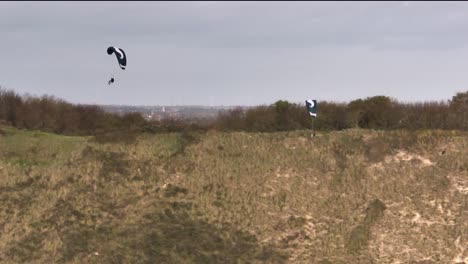 two experienced paragliders soar along coastal dunes, adrenaline sport