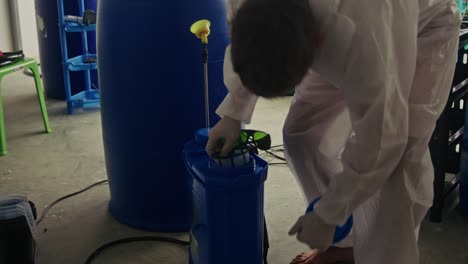 cannabis grow operation: worker applying pesticide