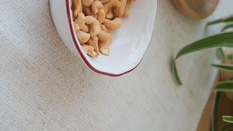 a bowl of roasted cashews on a table
