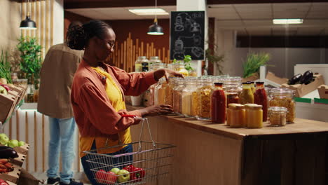 Female-client-checking-variety-of-grains-or-pasta-in-reusable-jars