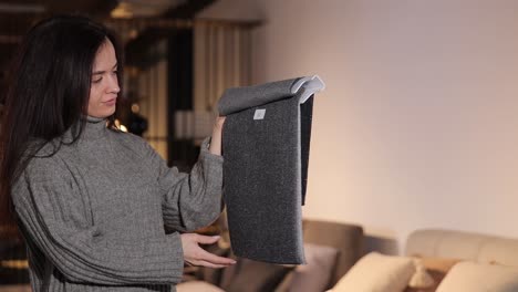 a pretty woman with dark hair chooses upholstery for her sofa in a furniture store a pretty woman with dark hair chooses upholstery for her sofa in a furniture store high quality footage