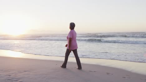 Ältere-Afroamerikanische-Frau,-Die-Am-Strand-Spaziert