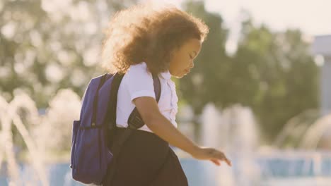 schoolgirl walking near fountain