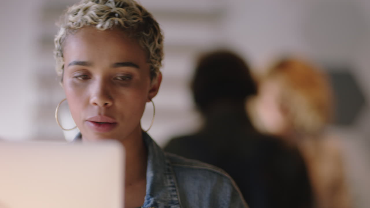 young african american business woman using laptop computer in cafe sharing lifestyle ideas on social media typing email enjoying drinking coffee blogging listening to music wearing headphones