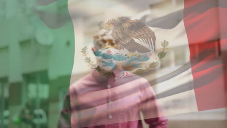 animation of flag of mexico waving over african american man wearing face mask in city street