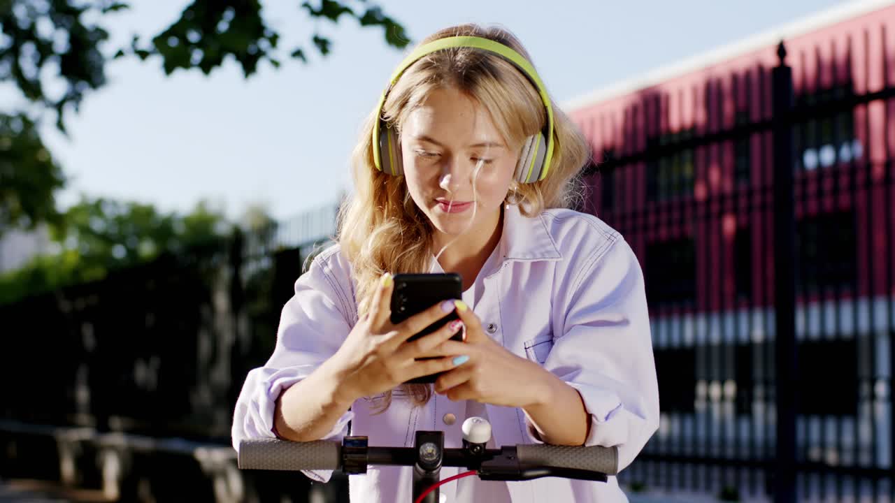 Very pretty lady student in the middle of the street with a large smile make a stop with her electric scooter and texting someone she make a excited and thinking face