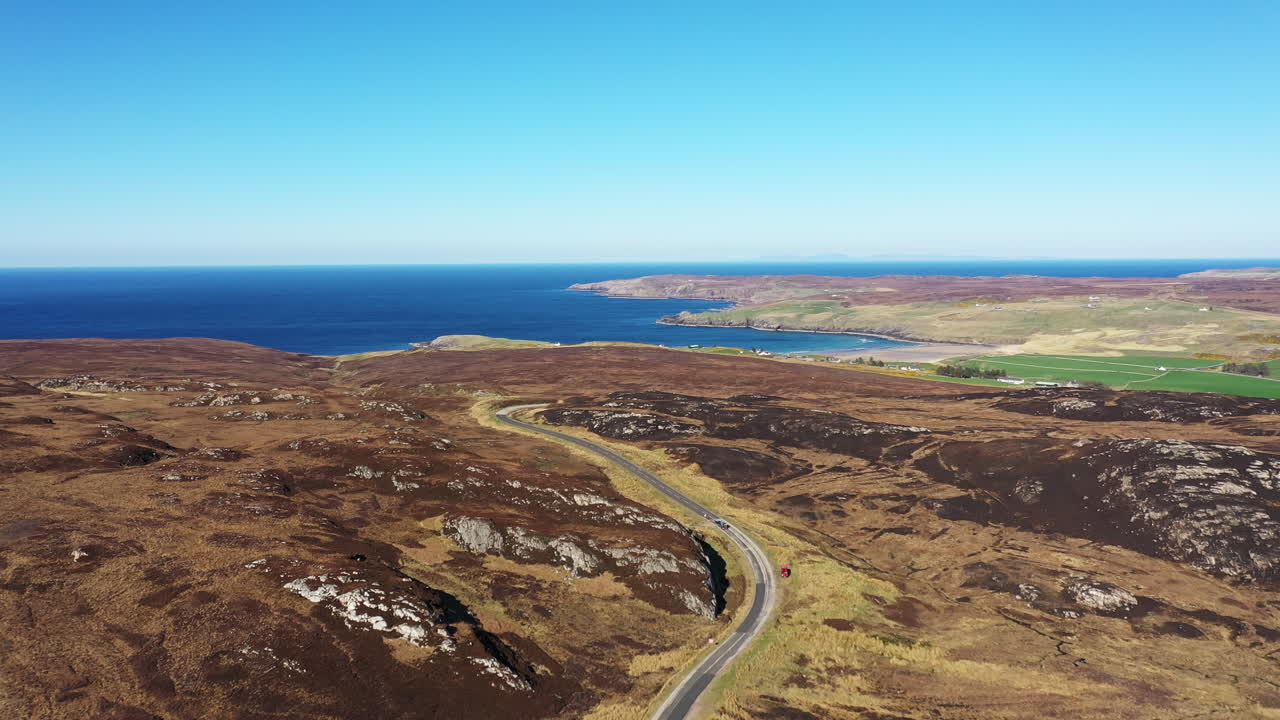 drone barrido disparado sobre una carretera en un paisaje remoto por el mar en un día soleado