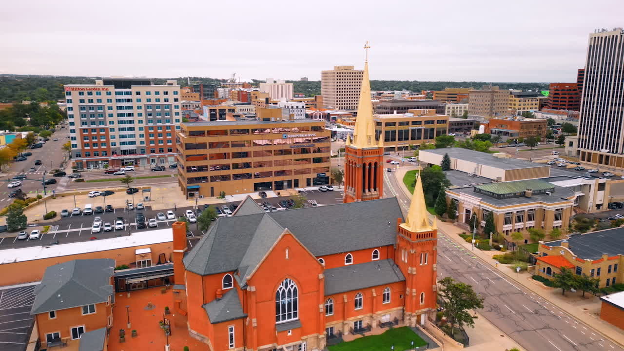 Colorado Springs, USA, 22 July 2025: Red brick building of St. Mary's Cathedral from drone footage. A parking lot with cars parked at backdrop. Colorado Springs, Colorado, USA