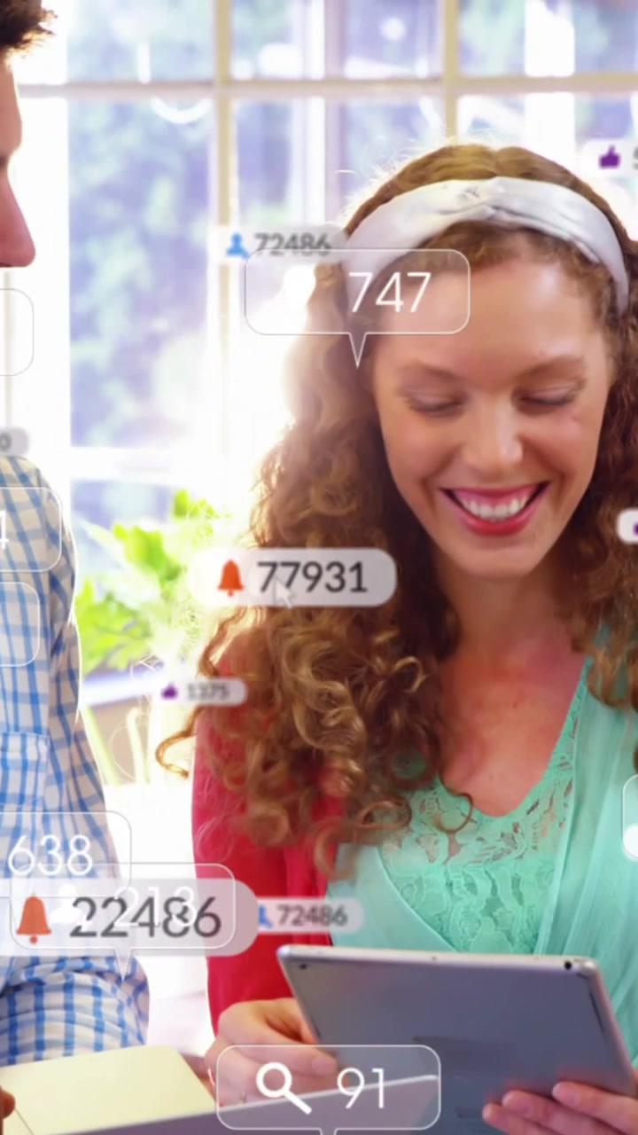 Animation of changing numbers and notification icons over diverse coworkers discussing over tablet