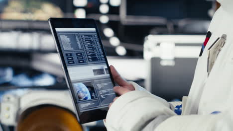 Close up of astronaut using tablet to check Mars telemetry data