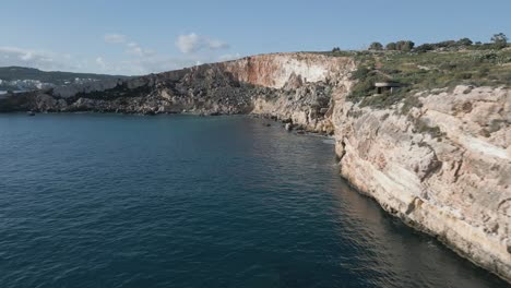 drone footage over the sea at malta island, next to a beatiful cliff