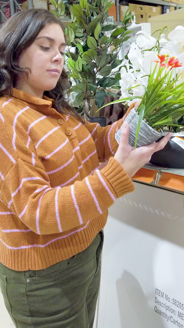 Woman choosing artificial plants in a store