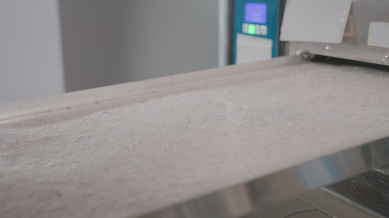 Keyholder hands open industrial washer filter drawer with key, ensure proper maintenance, hygiene, safety inside modern laundromat, stainless machines lined in row under routine service