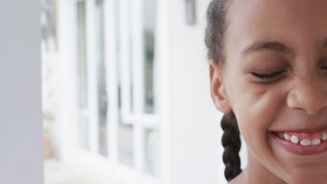 Half-portrait-of-happy-biracial-girl-at-home-with-copy-space,-slow-motion