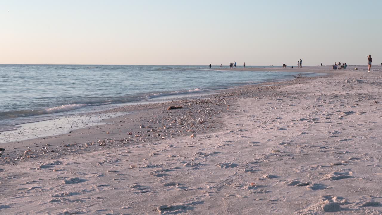 화창한 날 모래사장 위로 굴러가는 파도의 아름다움