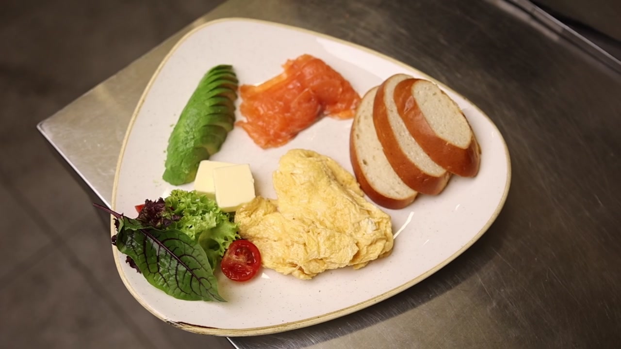 Piatto sano per la colazione con avocado, salmone affumicato, uova e pane