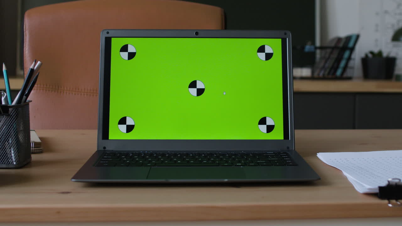 Laptop with Green Screen Calibration Pattern on a Wooden Desk