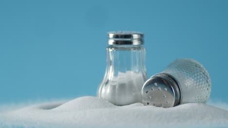 cans of salt slowly rotate on the table.