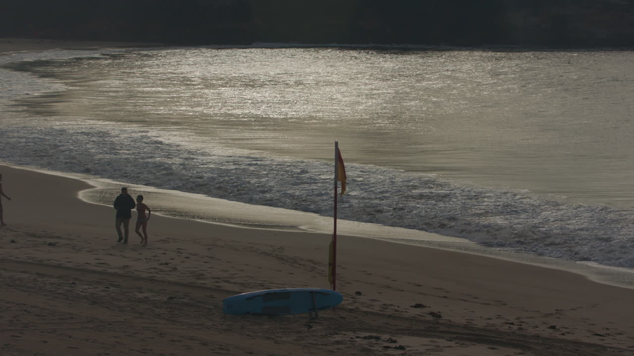 Waves crash in slow motion on Bondi Beach Sydney Australia infront of the Red and Yellow LifeSaver Flags in the early mornig