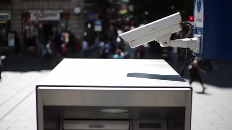surveillance system above cash withdrawal machine: a close-up view of a security camera installed at an atm in a busy public area, monitoring activity and ensuring safety