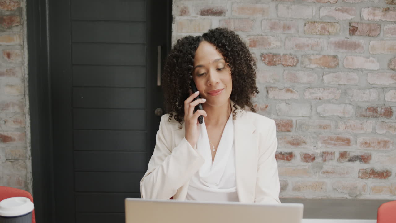 Una donna d'affari parla al telefono in un ambiente d'ufficio