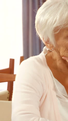 Unhappy senior woman sitting alone