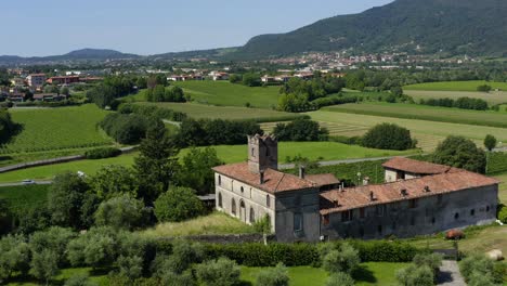 Aerial-Shot-Of-Ancient-Buildings-On-The-Large-Field-Of-Iseo-With-Mountains-In-Background-At-Iseo-In-Lombardy,-Italy