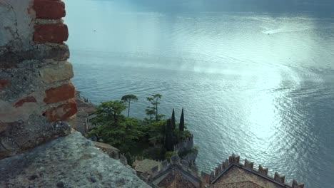 Maravíllate-Ante-La-Belleza-Del-Lago-De-Garda-Desde-La-Muralla-De-Un-Castillo,-Que-Ofrece-Una-Perspectiva-única