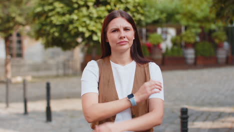 upset caucasian woman reacting to unpleasant awful idea shaking finger at camera on city street