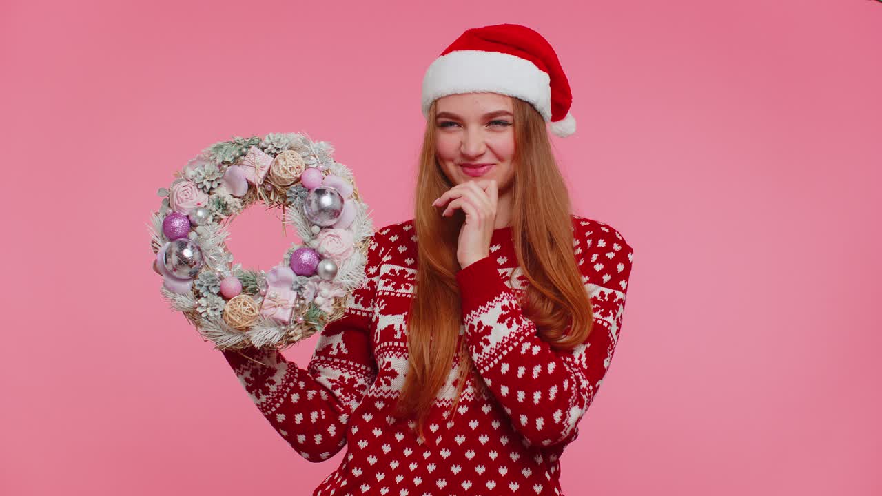 은 크리스마스 휴일 스웨터를 입은 미소 짓는 성인 소녀 축제 꽃받침 장난감에 손가락을 올리십시오
