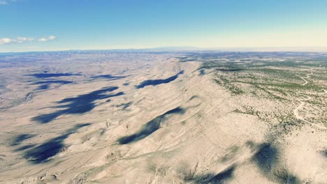 lincoln national forest mountain view, cloud shadows, aerial wide shot of hazy day in the mountains, rocky sedimentary highlands, large cliff valley in new mexico