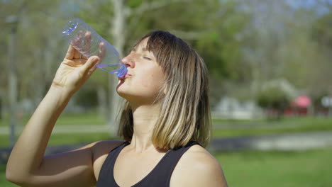 Schöne-Junge-Frau-Trinkt-Wasser-Aus-Einer-Plastikflasche.