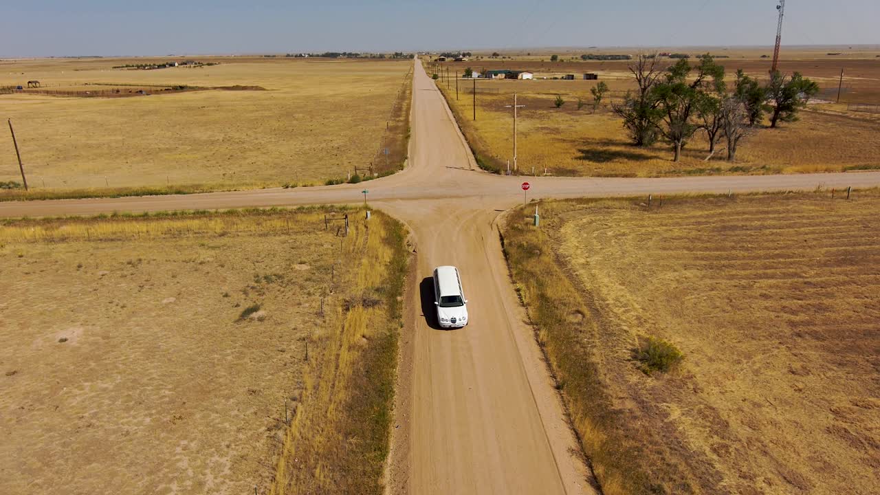 una limusina conduce por un camino rural en 4k desde un dron