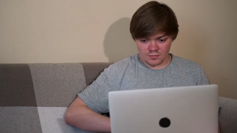 joven trabajando en una computadora portátil en casa