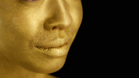 close-up of a woman's face with gold makeup