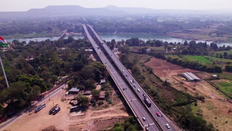 Tilwara bridge with crop fields lands and national flag at jotpur, jabalpur, madhya pradesh, india. day time, semi orbit, drone shot, 4k.