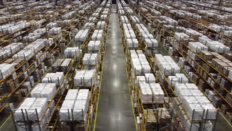 aerial view of an extensive warehouse featuring rows of organized pallets and products in a large storage facility, highlighting efficient inventory management