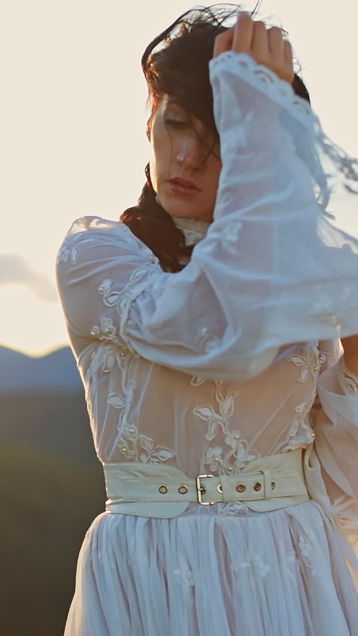 Outdoor happy woman dancing on the nature. Young beautiful lady in dress walking in mountains. Vertical video