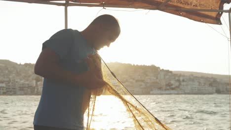 traditional greek fisherman maintains fishing nets cinematic sunset golden hour